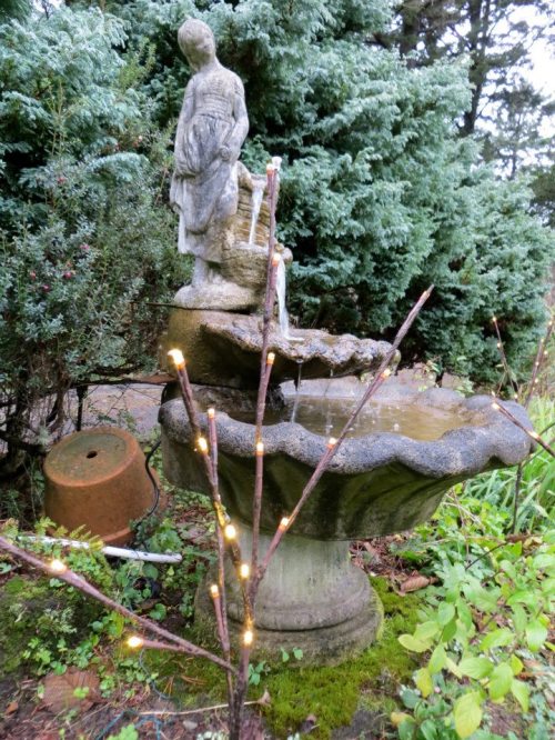 the lady fountain in the lawn bed