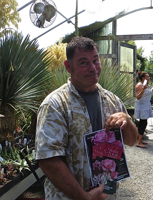 Sean takes on of our garden tour posters (it's this Saturday, July 19th!) and poses for Garden Tour Nancy.